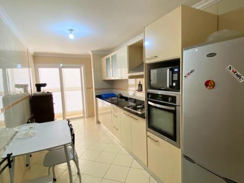a kitchen with a refrigerator and a table in it at Mar & Morna in Mindelo