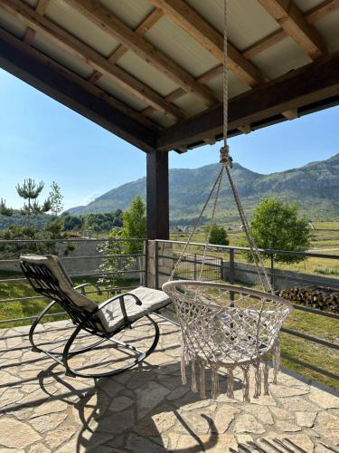 a swinging chair on a patio with a view at Holiday House Korita in Podgorica