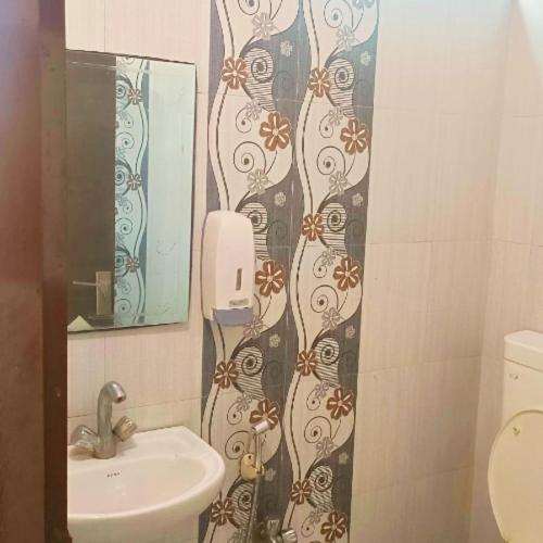 un baño con lavabo y espejo en Hotel Gem, en Jaipur