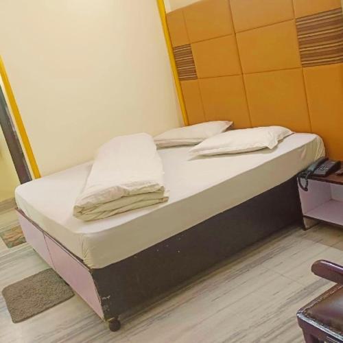 Una cama en una habitación con dos almohadas encima. en Hotel Gem, en Jaipur