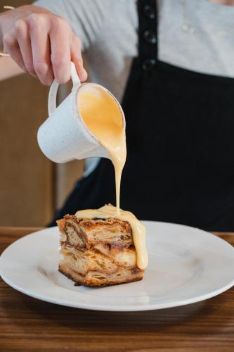 a person is pouring peanut butter on a piece of food at The Royal Sutton in Sutton Coldfield