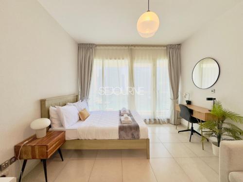 a bedroom with a bed with a desk and a window at DA86 - Well Design Studio in Dubai Arch tower in Dubai