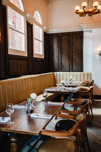 a restaurant with wooden tables and chairs and windows at The Royal Sutton in Sutton Coldfield