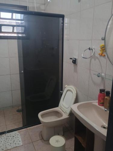 a bathroom with a shower and a toilet and a sink at Ambiente Familiar in Ubatuba