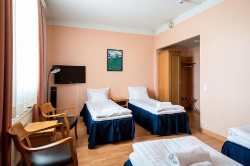 a hospital room with two beds and a tv at Hiisi Hotel Turku Seaport in Turku