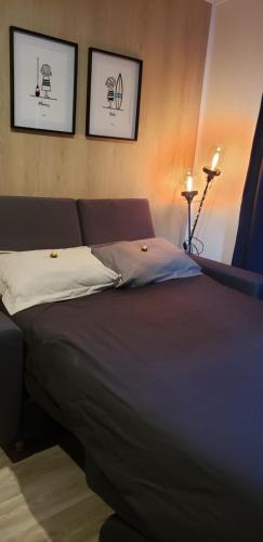 a bed in a bedroom with two pictures on the wall at Studio de jardin au calme in Hennebont
