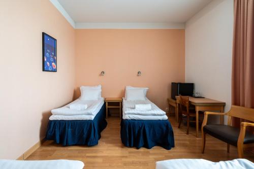 a hospital room with two beds and a table at Hiisi Hotel Turku Seaport in Turku