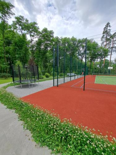 a tennis court with a net and flowers on it at Mayak Resort in Kyiv