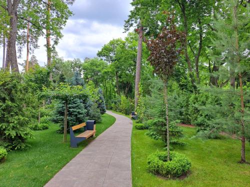 a path in a park with a bench and trees at Mayak Resort in Kyiv