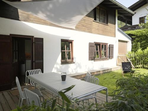 a patio with a table and chairs in front of a house at Alpenchalet Reit im Winkl in Reit im Winkl