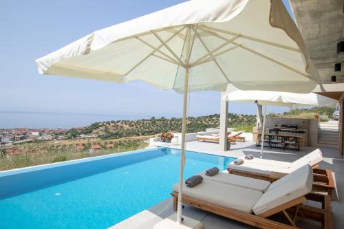 ein Pool mit zwei Stühlen und einem Sonnenschirm daneben in der Unterkunft Villa Lume Nea Skioni by Halkidiki Villas in Nea Skioni