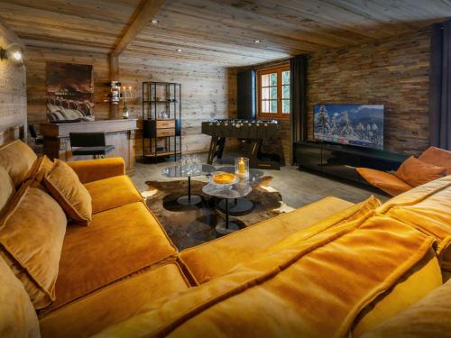 - un salon avec un canapé et un piano dans l'établissement Chalet Loisel - OVO Network, à Saint-Jean-de-Sixt
