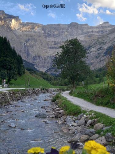 a river with rocks and mountains in the background at Gite Le Moulin prés de Tarbes, Lourdes, Bagnères de bigorre 2 à 6 personnes, deux étoiles in Mascaras