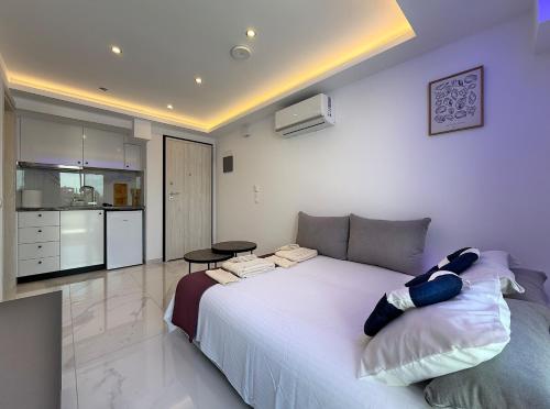 a bedroom with a large white bed and a kitchen at IFESTOS SUITES by SDR in Paralia Katerinis