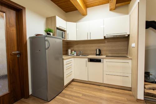 a kitchen with white cabinets and a refrigerator at Wellness Hotel Říčky in Říčky