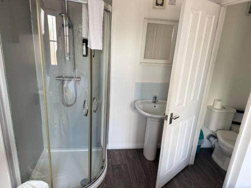 a bathroom with a shower and a toilet at Cabin 6 in Bradwell on Sea