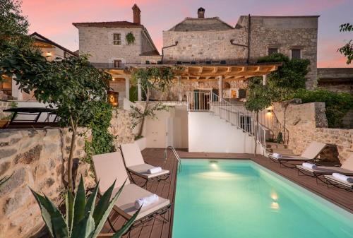 a house with a swimming pool in front of a building at Villa Irma in Pitve
