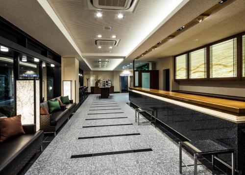 a lobby with couches and a bar in a building at Fukui Manten Hotel Ekimae in Fukui