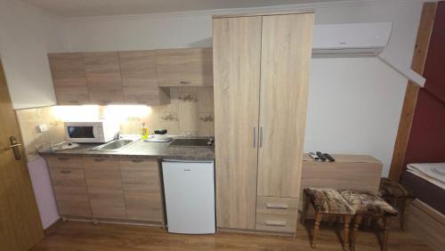 a small kitchen with a sink and a refrigerator at Penzión Korzo in Štúrovo