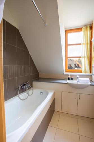 a bathroom with a bath tub and a sink at Apartmány pod Zakletým - Hotel Říčky in Říčky