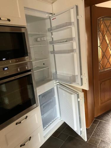 an empty refrigerator with its door open in a kitchen at Elb- Havel Ferienhaus in Schönhausen