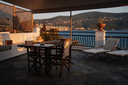 a table and chairs on a balcony with a view at Roditses Beach Sea Front Apartments in Samos