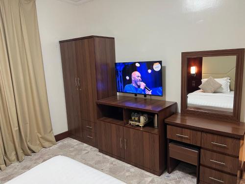 a room with a tv and a bed and a mirror at Dalin Hotel in Riyadh