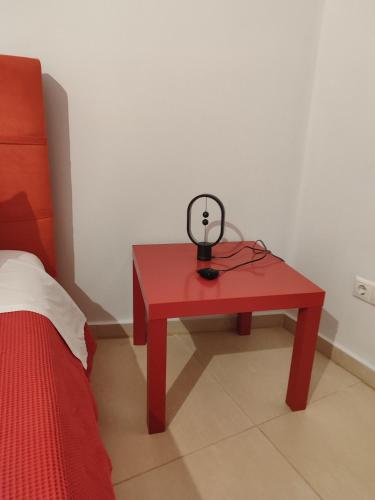 a red table with a lamp on it next to a bed at Δροσιά in Nafplio