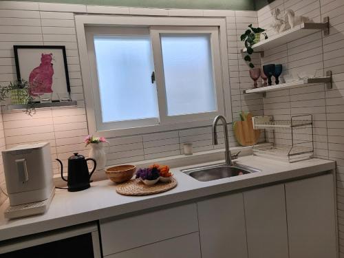 a kitchen counter with a sink and a window at Ora Stay Anyang in Anyang