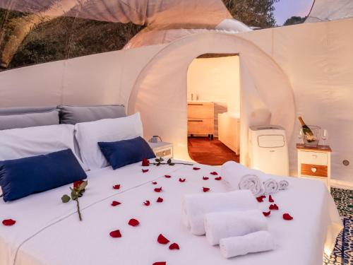 a white bed with roses on it in a room at Tenuta Lu Baroni in Porto Ottiolu