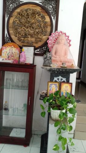a shelf with a statue and a potted plant at The Sanhida Guest House Colombo in Nugegoda