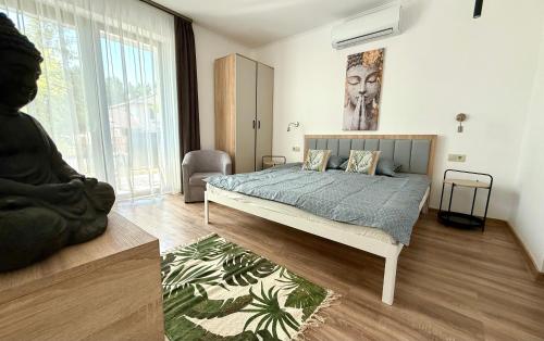 a bedroom with a bed and a large window at Zen apartmanház Gyula in Gyula