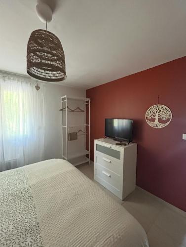 une chambre avec un lit et une télévision sur un mur dans l'établissement Le Pachoquin, à Méounes-lès-Montrieux