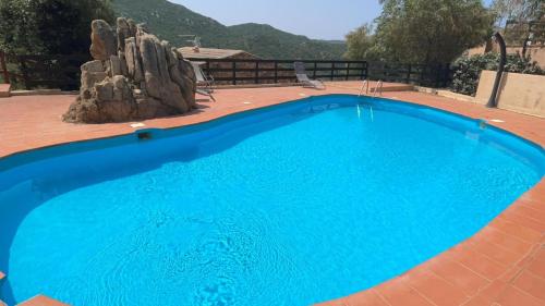 Una gran piscina azul en un patio. en Appartamento- La Falata, en Costa Paradiso