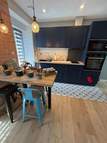 a kitchen with blue cabinets and a wooden table at Maison Sorbier, Appartement 1 in Nevers