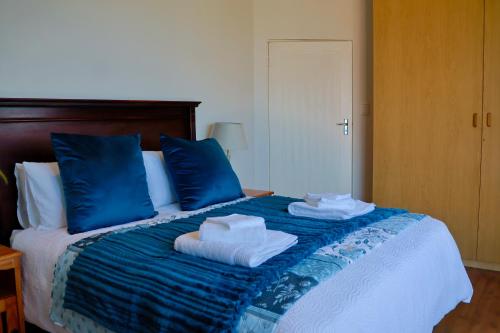 una camera da letto con cuscini blu e asciugamani su un letto di Apartment Sapphire a Herolds Bay
