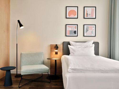 a bedroom with a bed and a chair at Garner Hotel Berlin - Schöneberg by IHG in Berlin