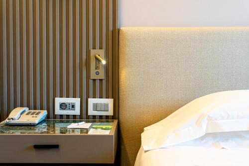 a hotel room with a bed and a phone on a table at Abacus Hotel in Sesto San Giovanni