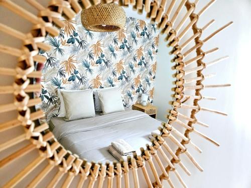 - un miroir réfléchissant le lit dans la chambre dans l'établissement Doux Murmures, appartement 73m2 calme et élegant, 2 chambres, à Mâcon