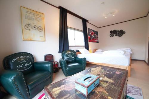 a bedroom with a bed and two chairs and a table at 【芦ノ湖徒歩10分＆バス停1分】一棟貸切最大14人 大人數BBQ可能 パーティ 『ROUTE99』 in Moto-hakone