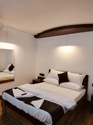 a bedroom with a large bed with white and black pillows at RKs HOME STAY in Shillong