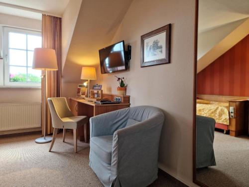 a hotel room with a desk and a bedroom at Hotel Zum Stein Wellness & Genuss Resort in Oranienbaum-Wörlitz