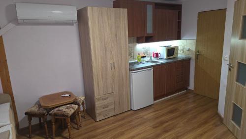 a small kitchen with a white refrigerator and a table at Penzión Korzo in Štúrovo