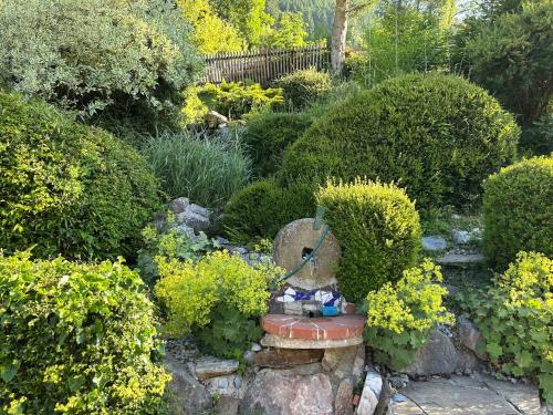 a garden with a statue in the middle of some bushes at Wohnstudio in umgebauter Scheune in Altlassing