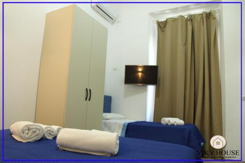 Habitación con 2 camas, espejo y armario. en Viki House, en Reggio Calabria