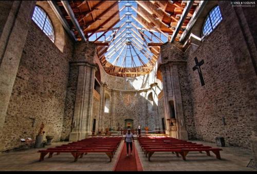 a person standing in a church with red benches at Apartmán Lesněnka in Říčky