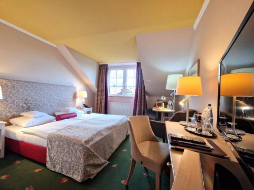 a hotel room with a bed and a desk at Hotel Zum Stein Wellness & Genuss Resort in Oranienbaum-Wörlitz
