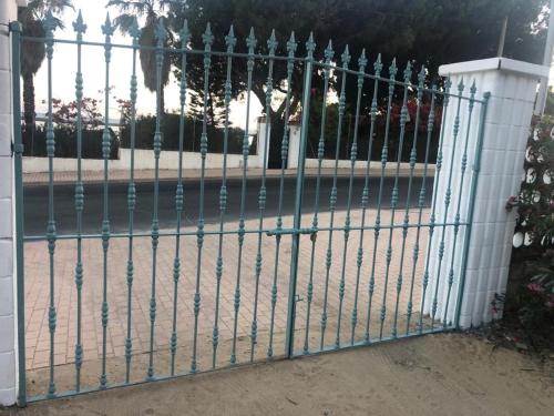 a gate in front of a building with a fence at BHost - Bungalows Mazagón in Palos de la Frontera