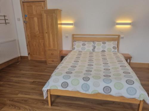 a bedroom with a bed with a wooden head board at The Albert Hotel in Gloucestershire