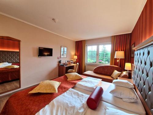 a hotel room with a large bed and a window at Hotel Zum Stein Wellness & Genuss Resort in Oranienbaum-Wörlitz